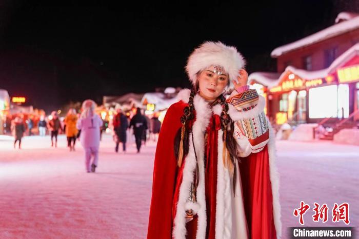 赤い豪華な古代のお姫様の衣装を着て雪景色をバックに写真を撮影する女性（撮影・趙宇航）。