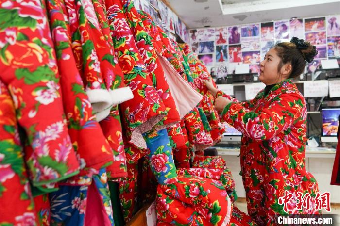 観光客に東北エリアならではの鮮やかな色合いの花柄の綿入れをレンタルするショップ（撮影・趙宇航）。