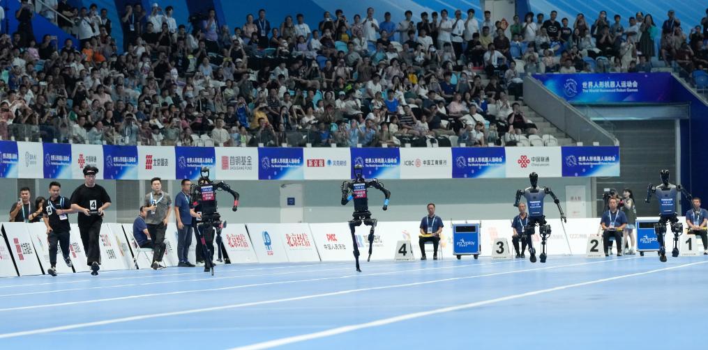 8月17日、世界人型ロボット競技大会100メートル決勝で、スタートを切った天驍チーム（右一）、天工チーム（右二）、高羿科技チーム（左二）、霊翌科技チーム（左一）の人型ロボット。撮影・鞠焕宗